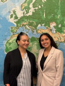 Dr. Dumas and Esmeralda Regalado pose together in front of the map wall. 