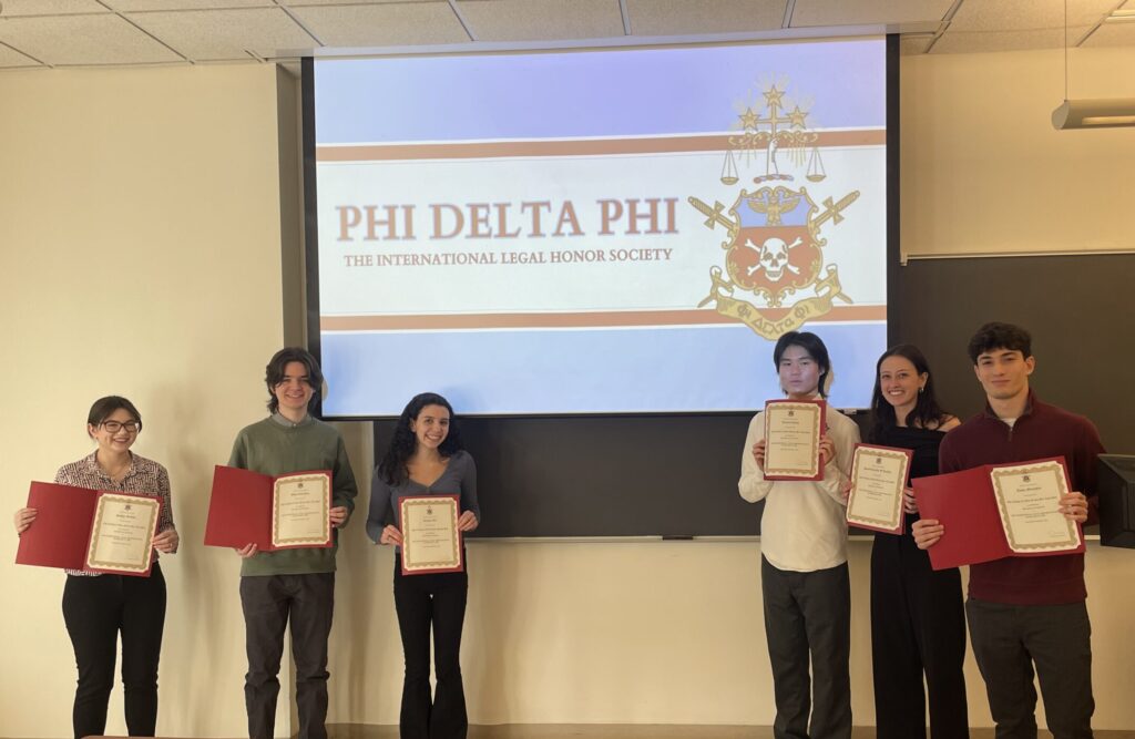 Six of the newly inducted members of the Honor Society hold up their certificates for a group photo.